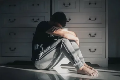 Trist mand sidder på gulv og oplever en frygt for at blive forladt