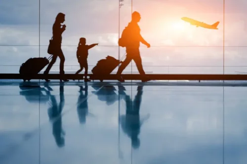 En familie i en lufthavn repræsenterer emigration med børn
