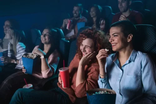 Personer griner i biograf og nyder filmindustrien