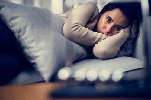 Deprimeret kvinde i sofa oplever angst og depression ved OCD
