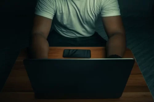 Mand ved computer repræsenterer cybertyveri