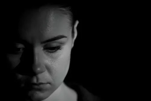 Trist kvinde i mørke repræsenterer livet efter et traume