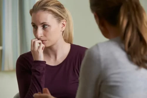Kvinde ser utryg ud, mens hun taler med en anden kvinde