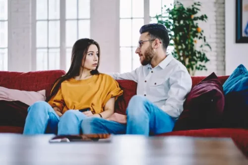 Par i sofa illustrerer diskussioner i et forhold