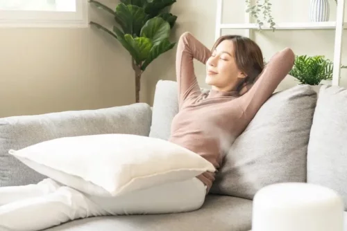 Afslappet kvinde på sofa oplever, hvordan en bolig påvirker dit mentale helbred