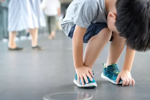 En dreng rører ved sine sko