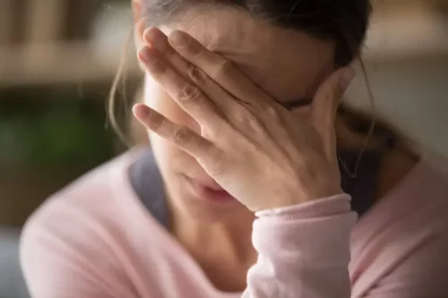 Frustreret kvinde tager sig til hovedet og repræsenterer, hvordan narcissister kan gøre os syge
