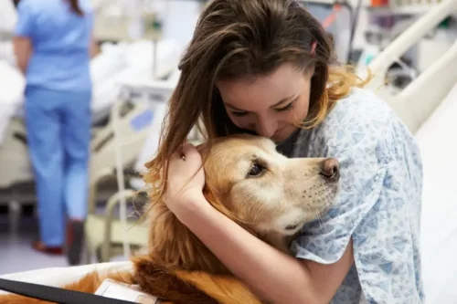 En kvindelig patient krammer en hund
