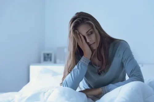 Trist kvinde sidder i seng