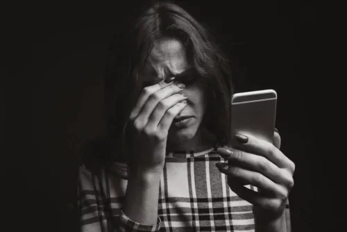 Frustreret kvinde med telefon i hånden er offer for identitetstyveri på sociale medier