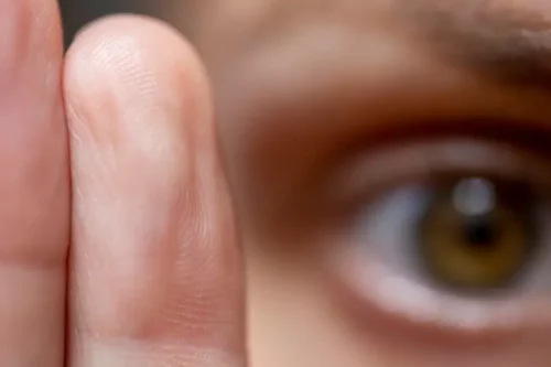 Nærbillede af fingre foran et øje