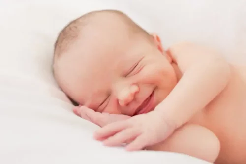 Baby smiler i søvne