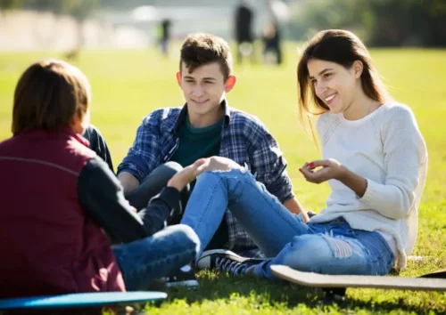 En gruppe unge mennesker sidder sammen på græs