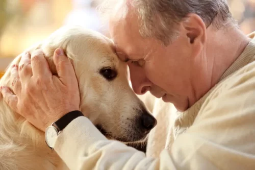 Mand krammer hund og repræsenterer, at det styrker hjernen at eje en hund