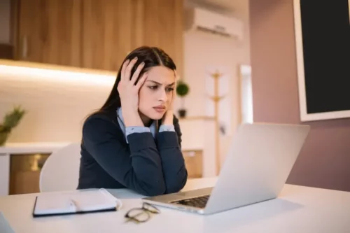 Frustreret kvinde ser på computer