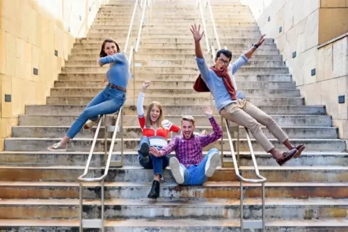 Glade unge mennesker på en trappe