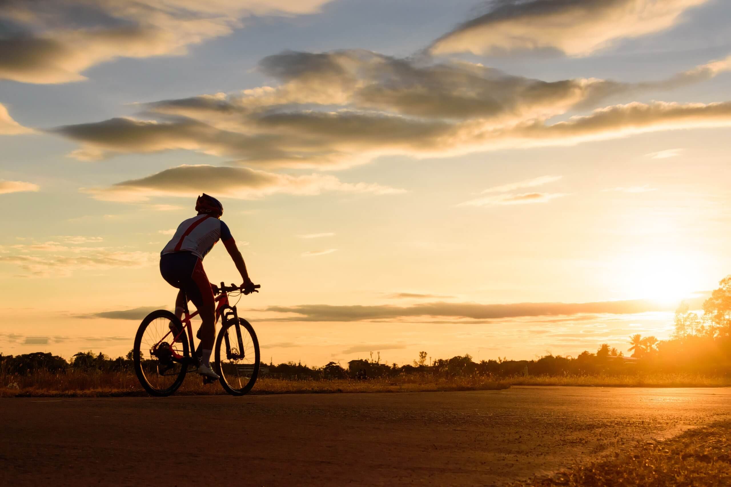 Person cykler og nyder solnedgang og de mentale fordele ved cykling